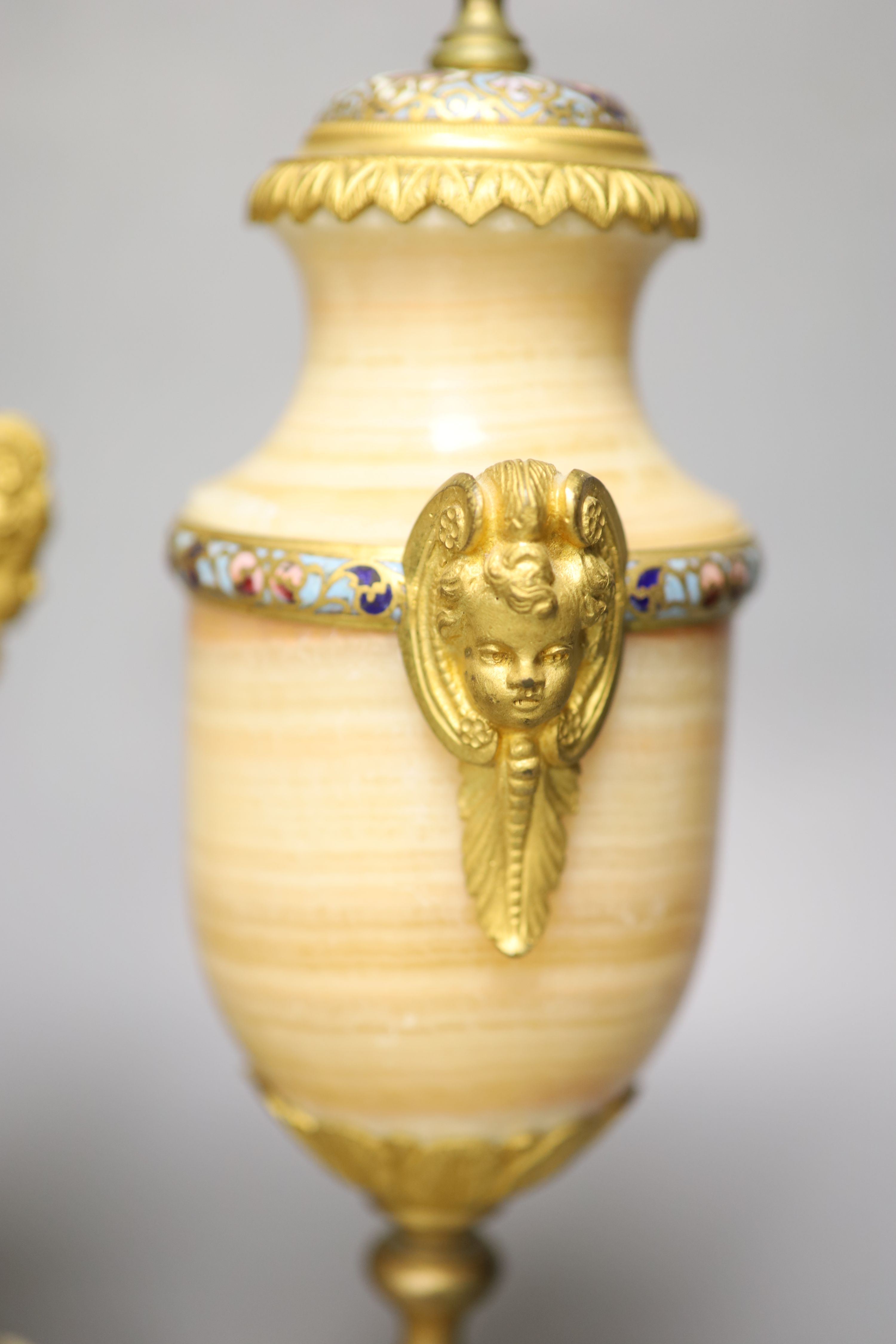 A pair of late 19th century alabaster and champleve enamel urns (formerly part of a clock garniture), height 32cm